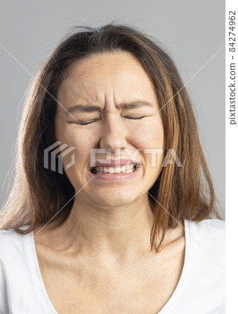 Portrait of young woman with facial expression . Portrait of young woman with facial expression . 84274962