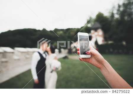 Young wedding couple taking a selfie of themselves Young wedding couple taking a selfie of themselves 84275022