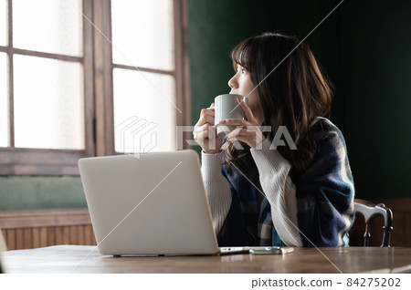 A beautiful Japanese woman relaxing with a cup of coffee with a copy space A beautiful Japanese woman relaxing with a cup of coffee with a copy space 84275202