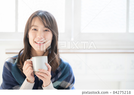A beautiful Japanese woman relaxing with a cup of coffee in a white room like a new house with a copy space A beautiful Japanese woman relaxing with a cup of coffee in a white room like a new house with a copy space 84275218