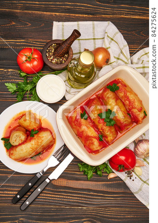 cabbage rolls stuffed with ground beef and rice with sour cream in a baking dish and ingredients cabbage rolls stuffed with ground beef and rice with sour cream in a baking dish and ingredients 84275624