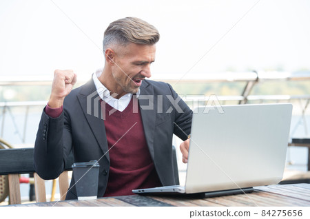 Got the job done in time. Happy man check watch and laptop. Punctuality. Manager make winning geture 84275656
