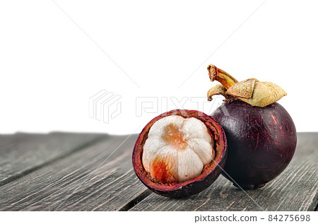Whole and opened mangosteen on table isolated on white Whole and opened mangosteen on table isolated on white 84275698