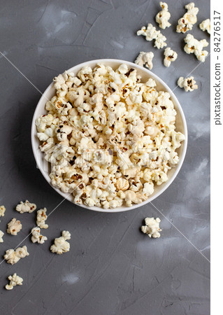 Popcorn in white bowl on grey table. Top view with copyspace Popcorn in white bowl on grey table. Top view with copyspace 84276517