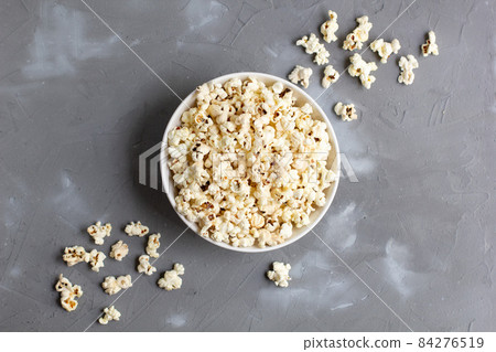 Popcorn in white bowl on grey table. Top view with copyspace Popcorn in white bowl on grey table. Top view with copyspace 84276519
