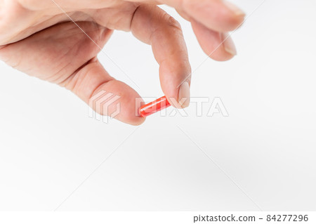 Hands of a man holding a capsule-shaped drug Hands of a man holding a capsule-shaped drug 84277296