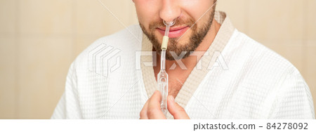 Young caucasian man receiving nasal inhalation Maholda with essential oil in the nose at a hospital. Young caucasian man receiving nasal inhalation Maholda with essential oil in the nose at a hospital. 84278092