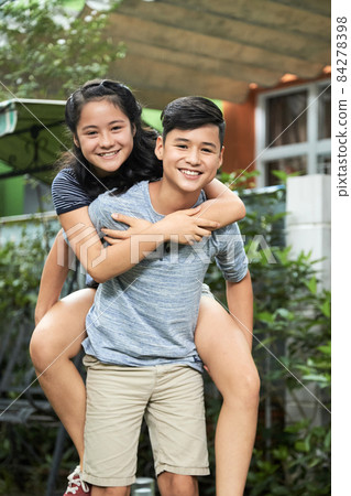 Boy Giving Piggyback Ride to Twin Sister Boy Giving Piggyback Ride to Twin Sister 84278398