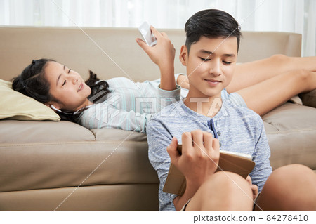 Siblings Resting with Gadgets 84278410
