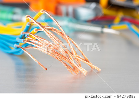 Copper cable wire and set of electrician tools in blurred background Copper cable wire and set of electrician tools in blurred background 84279882