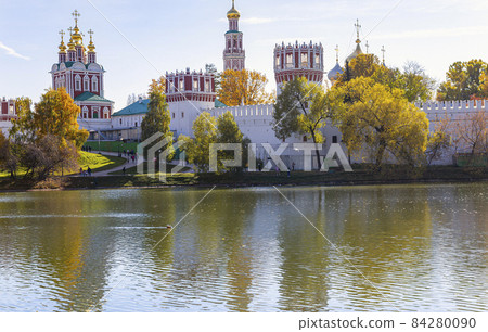 View of the Novodevichy convent (Bogoroditse-Smolensky monastery) and the big Novodevichy pond on a sunny autumn day. Moscow, Russia. UNESCO world heritage site 84280090