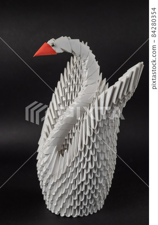 Japanese modular origami. White paper swan against a black backg 84280354