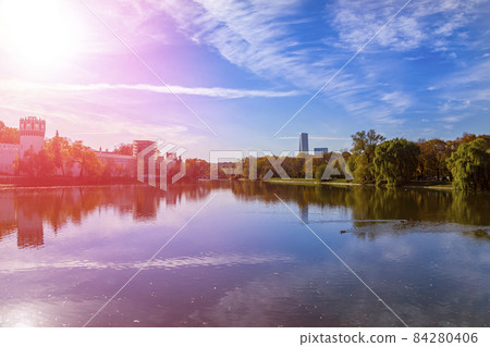 View of the Novodevichy convent (Bogoroditse-Smolensky monastery) and the big Novodevichy pond on a sunny autumn day. Moscow, Russia. UNESCO world heritage site 84280406