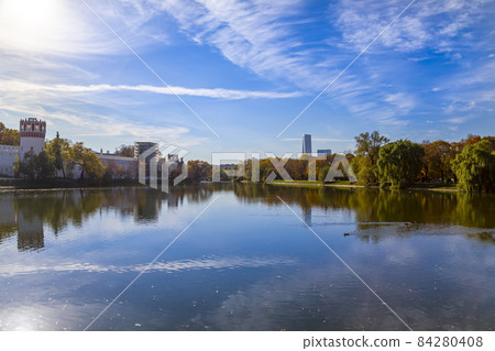 View of the Novodevichy convent (Bogoroditse-Smolensky monastery) and the big Novodevichy pond on a sunny autumn day. Moscow, Russia. UNESCO world heritage site 84280408