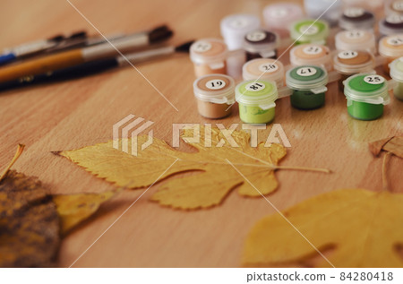 Yellow and brown Dried leaves, a set of acrylic paints and brush Yellow and brown Dried leaves, a set of acrylic paints and brush 84280418