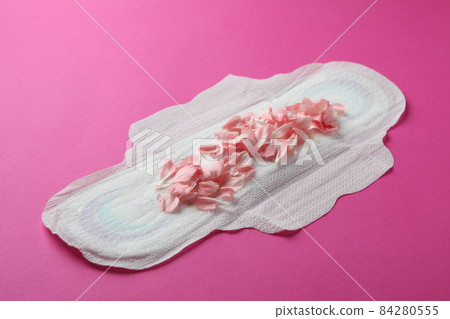 Hygiene pad with petals on pink background 84280555