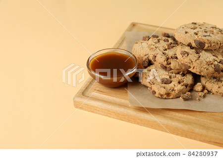 Board with cookies and caramel on beige background Board with cookies and caramel on beige background 84280937