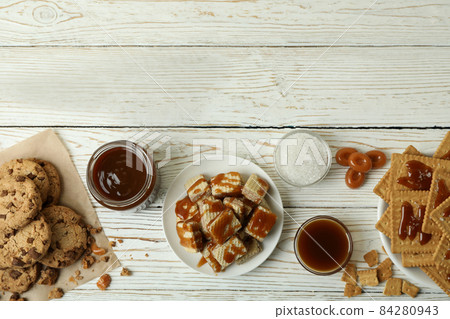 Tasty snack concept with cookies with caramel on white wooden table Tasty snack concept with cookies with caramel on white wooden table 84280943