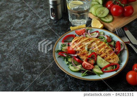 Concept of tasty eating with salad with grilled chicken on black textured table 84281331