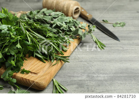 Fresh herbs on gray textured table, space for text 84281710
