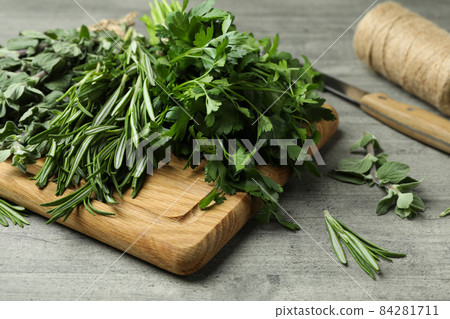 Fresh herbs on gray textured table, close up 84281711