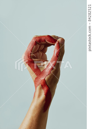 hand with a red ribbon for the fight against AIDS 84282521