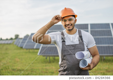 Indian technician in helmet posing at solar station 84284366