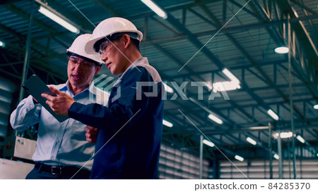 An engineer is explaining remote machine control to industrial owners. An engineer is explaining remote machine control to industrial owners. 84285370