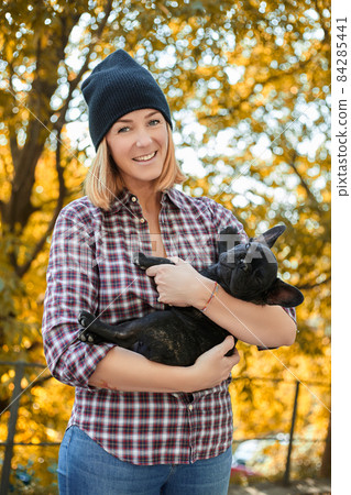 Closeup on happy young woman with dog outdoors in autumn Closeup on happy young woman with dog outdoors in autumn 84285441