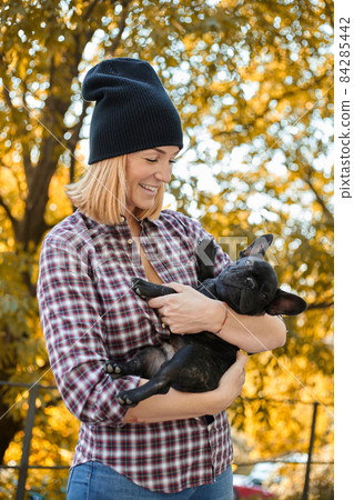 Closeup on happy young woman with dog outdoors in autumn Closeup on happy young woman with dog outdoors in autumn 84285442