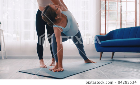 Pregnant woman doing Pilates exercise with personal trainer at home. 84285534