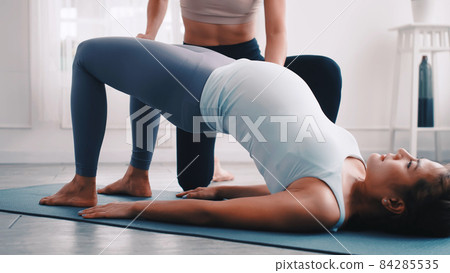 Pregnant woman doing Pilates exercise with personal trainer at home. 84285535