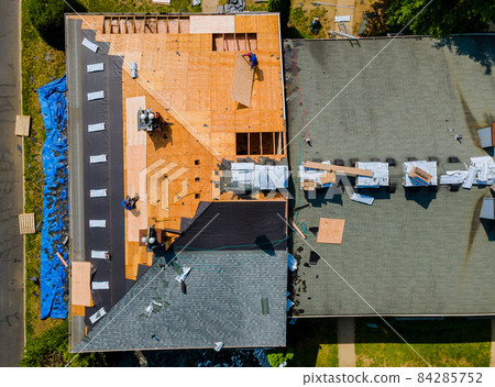 Construction worker on renovation roof the house installed new shingles 84285752