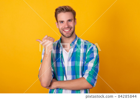 Your advert here. Happy man pointing thumb yellow background. Place your advert, copy space Your advert here. Happy man pointing thumb yellow background. Place your advert, copy space 84285844