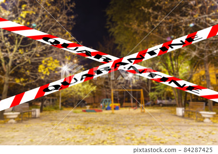 Coronavirus in Moscow, Russia. An empty playground on an autumn night in one of the residential areas (blurry view). Quarantine sign. Concept of COVID pandemic and travel Coronavirus in Moscow, Russia. An empty playground on an autumn night in one of the residential areas (blurry view). Quarantine sign. Concept of COVID pandemic and travel 84287425