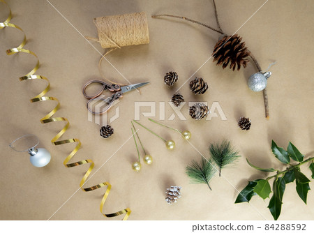 Christmas do it yourself flatlay materials pine cone, branch, beads, scissors, ribbon, thread, eco-friendly accessories for handmade home holiday decor, simple objects, selective focus Christmas do it yourself flatlay materials pine cone, branch, beads, scissors, ribbon, thread, eco-friendly accessories for handmade home holiday decor, simple objects, selective focus 84288592