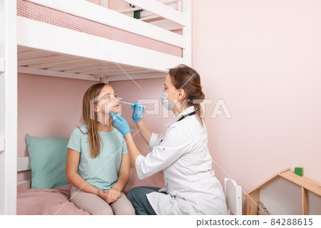Pediatrician taking nasal test sample from child at home during lockdown 84288615