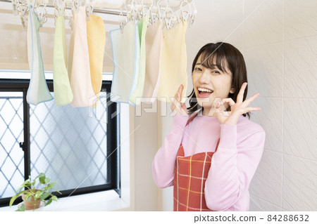 A woman who smells a towel dried in the bathroom and gives a ○ sign A woman who smells a towel dried in the bathroom and gives a ○ sign 84288632