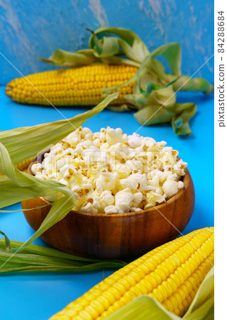 Popcorn raw organic yellow Corn on the Cob Ready to Eat. On blue background. Vertical photo Popcorn raw organic yellow Corn on the Cob Ready to Eat. On blue background. Vertical photo 84288684