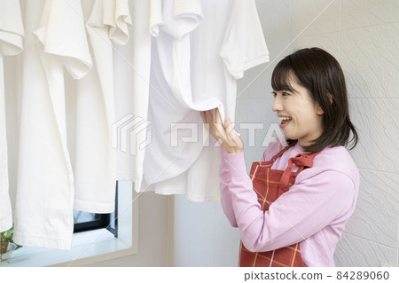 A woman who smiles by smelling a towel dried in the bathroom A woman who smiles by smelling a towel dried in the bathroom 84289060