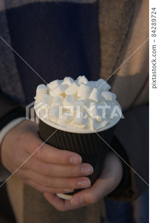 Hot take away beverage with an abundance of marshmallows and cream Hot take away beverage with an abundance of marshmallows and cream 84289724