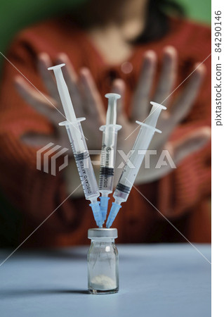 Woman refusing covid-19 vaccine. Anti-vaxxer activist showing stop sign to coronavirus vaccine vial with syringes. Vaccine scepticism. Anti-immunisation campaign. People rejecting covid vaccine 84290146
