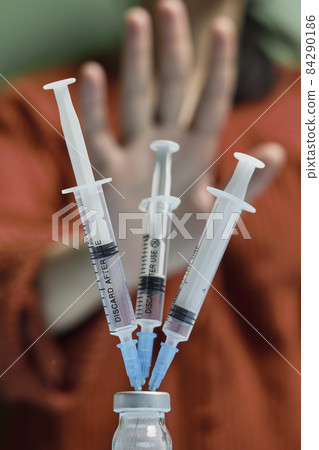 Woman refusing covid-19 vaccine. Anti-vaxxer activist showing stop sign to coronavirus vaccine vial with syringes. Vaccine scepticism. Anti-immunisation campaign. People rejecting covid vaccine Woman refusing covid-19 vaccine. Anti-vaxxer activist showing stop sign to coronavirus vaccine vial with syringes. Vaccine scepticism. Anti-immunisation campaign. People rejecting covid vaccine 84290186