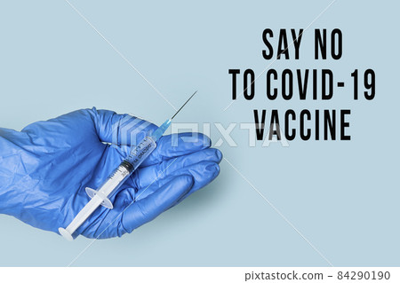 Doctor hand in medical gloves holds syringe with Covid-19 vaccine. Refusing immunization against coronavirus. Covid skepticism concept 84290190