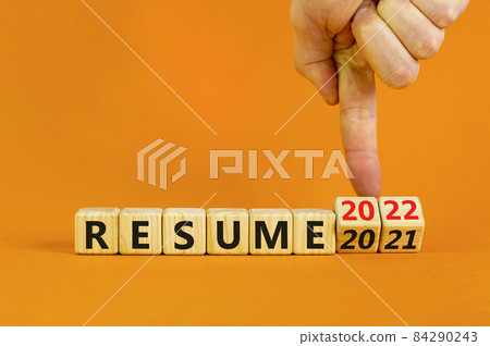 2022 resume and new year symbol. Businessman turns wooden cubes and changes words 'resume 2021' to 'resume 2022'. Beautiful orange background, copy space. Business, 2022 resume new year concept. 2022 resume and new year symbol. Businessman turns wooden cubes and changes words 'resume 2021' to 'resume 2022'. Beautiful orange background, copy space. Business, 2022 resume new year concept. 84290243