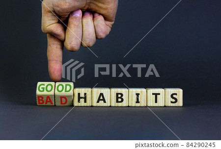 Good or bad habits symbol. Businessman turns wooden cubes and changes words 'bad habits' to 'good habits'. Beautiful grey table, grey background. Business, bad or good habits concept. Copy space. Good or bad habits symbol. Businessman turns wooden cubes and changes words 'bad habits' to 'good habits'. Beautiful grey table, grey background. Business, bad or good habits concept. Copy space. 84290245