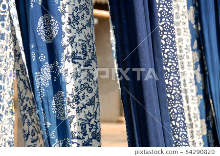 Wuzhen Water Town, Zhejiang Province, China. Indigo blue and white printed calico - a traditional cotton fabric produced in Wuzhen and a souvenir purchase for tourists. 84290820