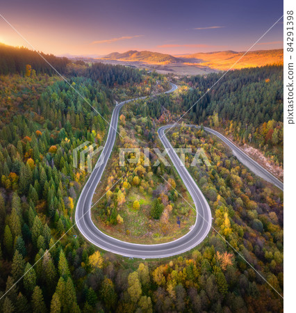 Aerial view of mountain road in forest at sunset in autumn 84291398