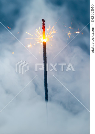 fire sparkler in dense smoke, abstract Christmas firework background fire sparkler in dense smoke, abstract Christmas firework background 84292040