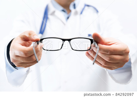 Optometrist holds glasses to try on Optometrist holds glasses to try on 84292097
